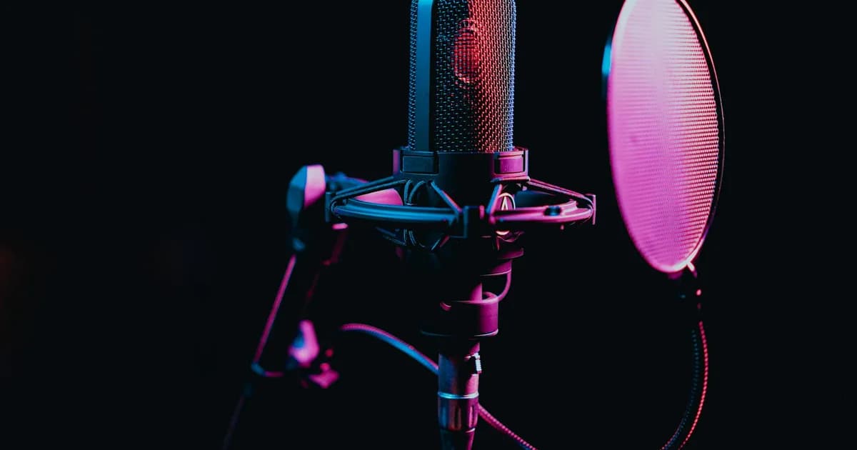 Close-up image of a condenser microphone with a pop filter in a studio setting, featuring atmospheric lighting.