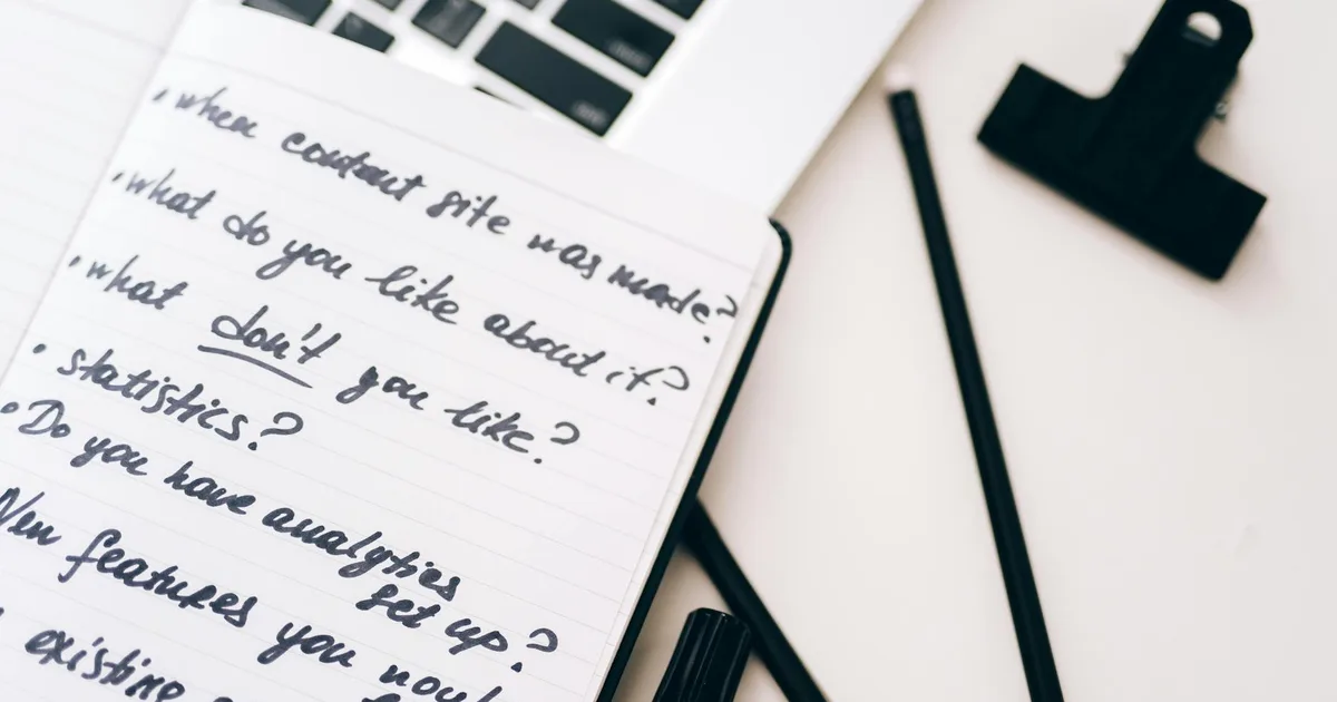 A close-up view of a notebook with handwritten notes alongside a laptop for planning and strategy.