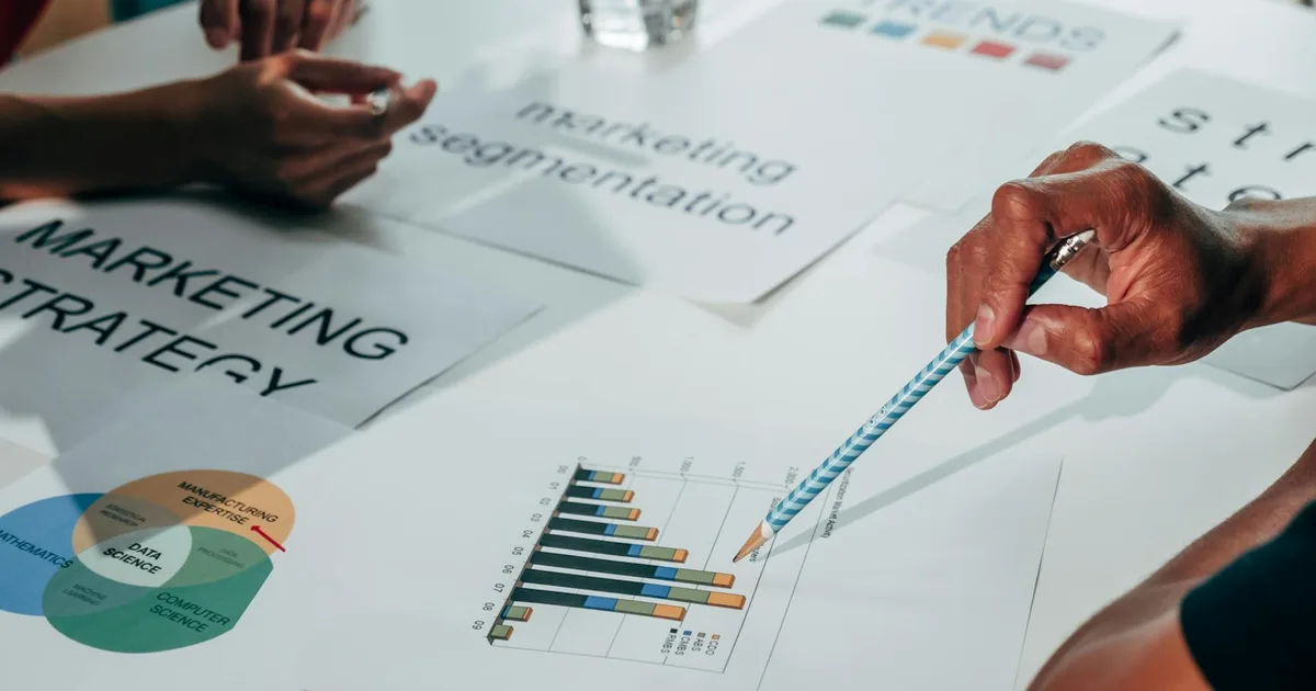 Team working on marketing strategy using data charts and papers in an office meeting.