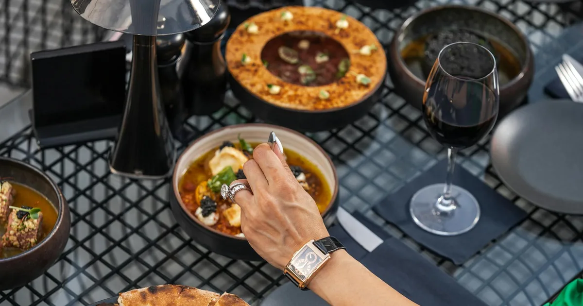 Luxury dining setting in Dubai featuring gourmet dishes and wine, perfect for a chic outdoor evening.