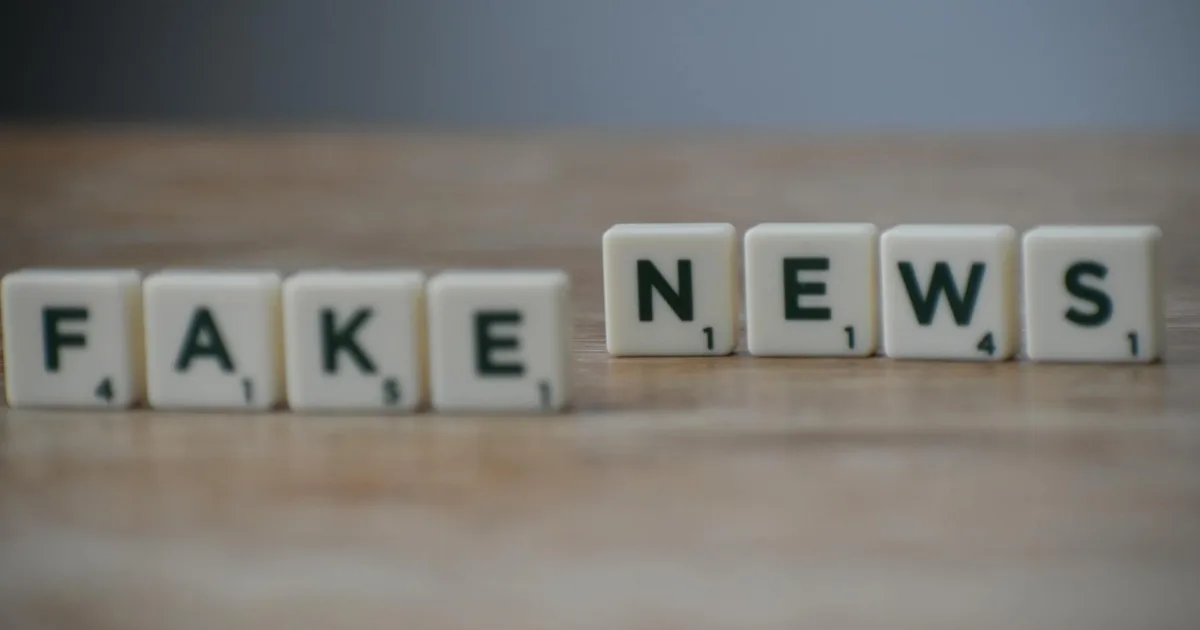 Scrabble tiles spelling 'Fake News' on a wooden surface highlighting misinformation.